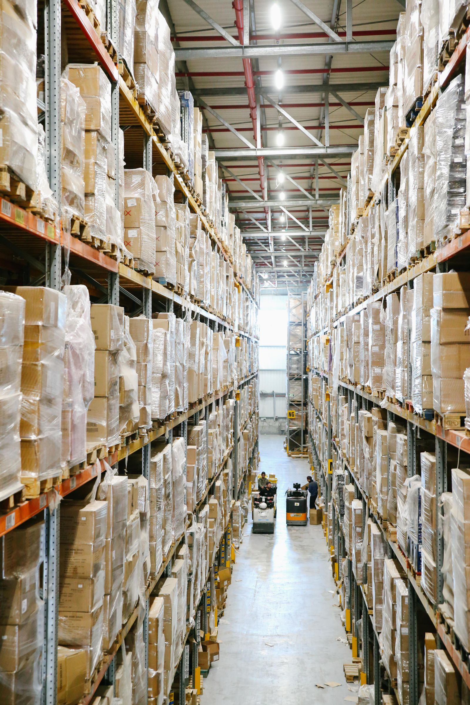 Organized warehouse aisle with palletized stock on tall shelves